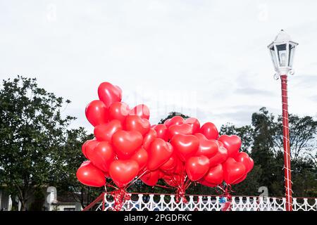 Ein schwimmender Strauß roter, herzförmiger Ballons Stockfoto