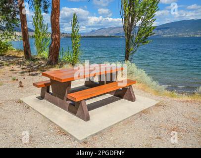 Picknicktisch und Bänke am Ufer des Okanagan Sees Stockfoto