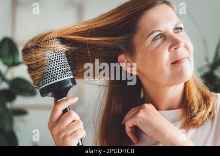 Eine Frau, die zu Hause ganz allein frisiert Stockfoto