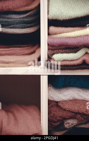 Ein Stapel bunter Strickkleidung - Pullover, Kleider, Strickjacken usw. Stockfoto