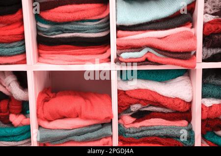 Ein Stapel bunter Strickkleidung - Pullover, Kleider, Strickjacken usw. Getöntes Foto. Stockfoto