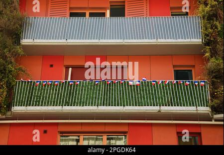 PARIS, FRANKREICH - 12. MÄRZ 2016: Rotes Gebäude mit französischen Flaggen im 15. Arrondissement (Viertel) von Paris. 15. Arrondissement ist das beste Stockfoto