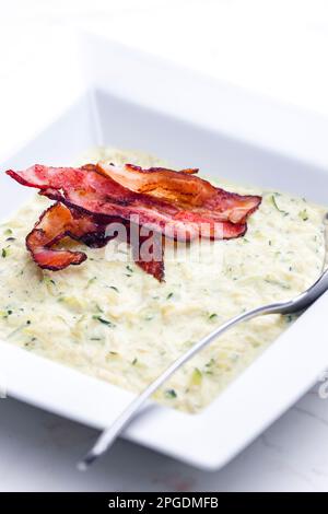 Zucchini-Suppe mit Speckstreifen Stockfoto