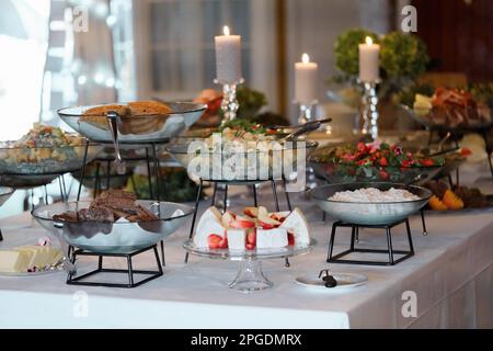 Hochzeitsbuffet mit verschiedenen Speisen, Snacks und Getränken auf dem Tisch. Esskonzept Stockfoto