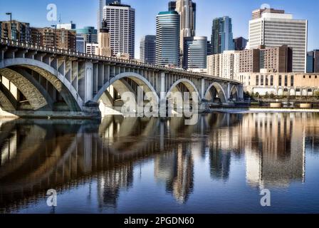 Das Minneapolis Ciity Center und die Third Avenue Bridge spiegeln sich am Mississippi River in Minnesota wider. Stockfoto