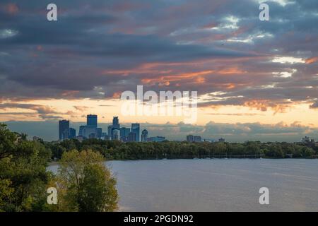 Der Sonnenaufgang färbt die Morgenwolken orange über Minneapolis und Lake Calhoun in Minnesota. Stockfoto