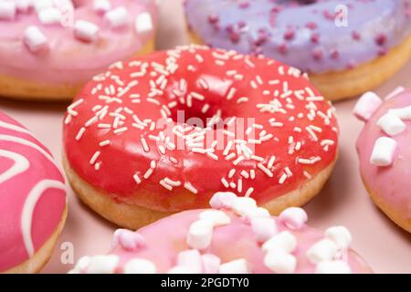 Donuts mit roter und rosafarbener Glasur, Draufsicht. Viele Donuts, süßes und köstliches Essen Stockfoto