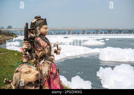 Neu-Delhi, Indien. 22. März 2023. Am 22. März 2023 steht eine Skulptur hinduistischer Götter am Ufer der verschmutzten Gewässer des Yamuna-Flusses in Neu-Delhi. Die Landeshauptstadt ist ein Hauptverursacher der Verschmutzung der Yamuna, auf die etwa 79 Prozent des gesamten Abwassers entfallen, das von den großen Städten entlang ihrer Ufer in den Fluss gegossen wird. Der Weltwassertag findet jedes Jahr am 22. März statt. (Foto: Mohsin Javed/Pacific Press) Kredit: Pacific Press Media Production Corp./Alamy Live News Stockfoto