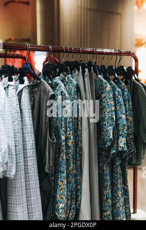 Blaue Sommerkleider für Frauen, die nacheinander an einem Kleiderbügel hängen. Modekollektion Stockfoto