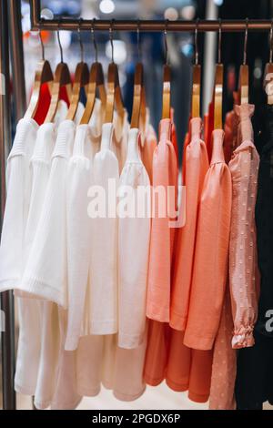 Pinkfarbene weiße Frauenblusen, die nacheinander an einem Kleiderbügel hängen. Frühlings-Sommerkollektion Stockfoto