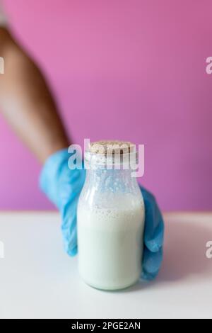 Nahaufnahme eines Arbeiters, der ein Milchgefäß für die Zubereitung von gerolltem Eis schnappt Stockfoto