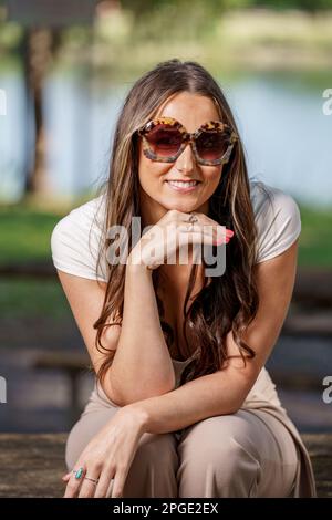 Modische junge Frau, die mit einer übergroßen Sonnenbrille posiert Stockfoto