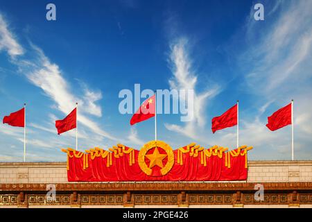Peking / China: Rote Flaggen wehen im Wind auf der Großen Halle des Volkshauses Stockfoto