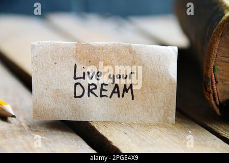 Lebe deine Traumkarte. Die Inschrift auf dem Schild. Vintage-Style. Motivierende Zitate. Stockfoto