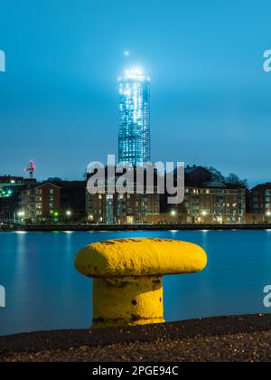 Gelber Pollard am Kai vor dem Stadtbild Stockfoto