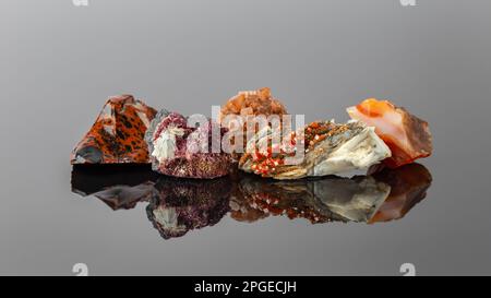 Gruppe von Steinen und Mineralien, die in einer Reihe angeordnet sind, einschließlich Vanadinit auf Barit, Aragonit Sputnik, Erythritkristalle, Mahagoni Obsidian und Carnelian Stockfoto