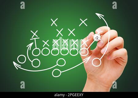 Coach zeichnet american Football oder Rugby-Spiel Playbook, Strategie und Taktik Plan in der Umkleide vor dunkelgrünem Hintergrund. Stockfoto