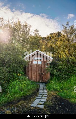 Rustikale Holzhütte im tiefen Wald im Nationalpark bei Sonnenuntergang Stockfoto
