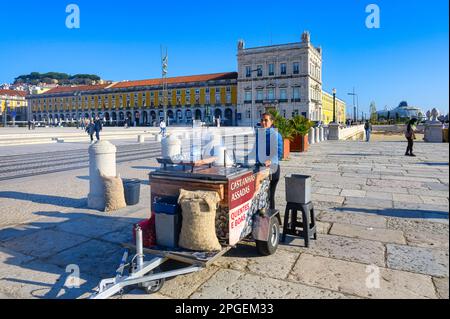 Eine Frau, die gebratene Kastanien auf dem Commerce Square, Lissabon, Portugal, verkauft Stockfoto