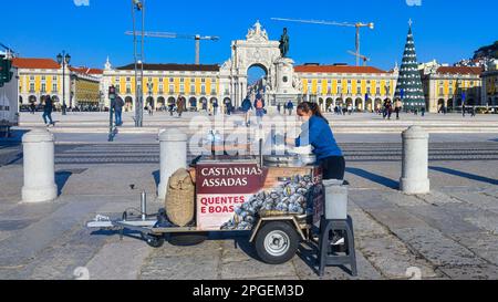 Eine Frau, die gebratene Kastanien auf dem Commerce Square, Lissabon, Portugal, verkauft Stockfoto