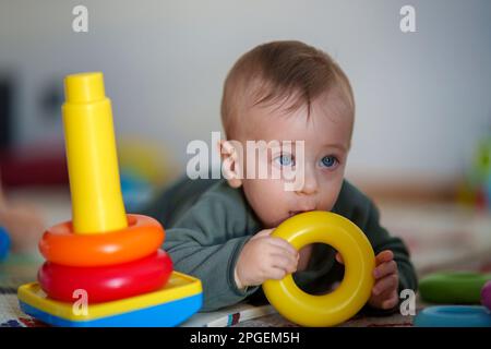 Ihr Baby spielt mit bunten, stapelbaren Ringen Stockfoto