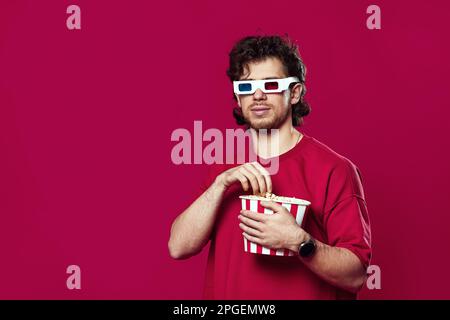 Ein Mann in 3D-Brille mit einem großen Eimer Popcorns Stockfoto
