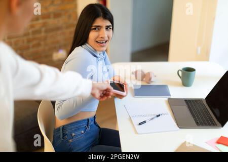 Mutter nimmt ihr Smartphone weg, weil es sie vom Lernen zu Hause ablenkt Stockfoto