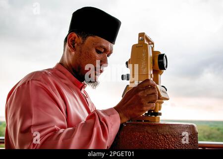 Ein Beamter des Islamischen Religionsrats von Selangor führt „rukyah“ durch, eine Mondsichterungszeremonie, um den Beginn des heiligen Monats Ramadan in Bukit Malawati zu bestimmen. Stockfoto