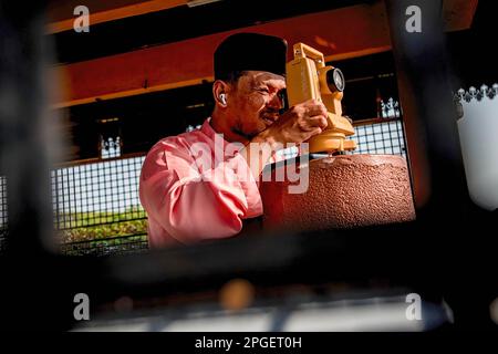 Ein Beamter des Islamischen Religionsrats von Selangor führt „rukyah“ durch, eine Mondsichterungszeremonie, um den Beginn des heiligen Monats Ramadan in Bukit Malawati zu bestimmen. Stockfoto