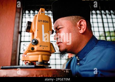 Ein Beamter des Islamischen Religionsrats von Selangor führt „rukyah“ durch, eine Mondsichterungszeremonie, um den Beginn des heiligen Monats Ramadan in Bukit Malawati zu bestimmen. Stockfoto