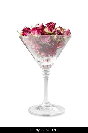 Knospen rosafarbener Rosen in einem isolierten martini-Glas. Knospen getrockneter Blüten in einem Glasbecher auf weißem Hintergrund. Getrockneter Blumentee. Valentinstag. Stockfoto