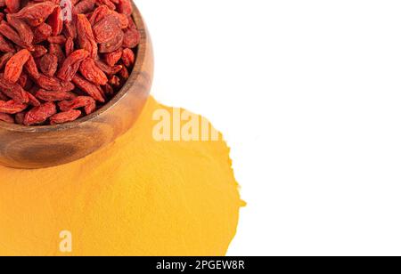 Dehydrierte Goji-Beeren und Goji-Beerenpulver, isoliert auf weißem Hintergrund Stockfoto