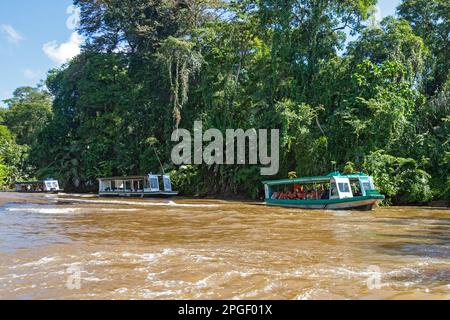 La Pavona, Costa Rica - Touristen fahren mit Booten auf dem Fluss Suerte für die einstündige Fahrt zum Tortuguero Nationalpark. Der Park kann nur mit bo erreicht werden Stockfoto