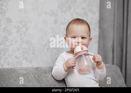 Süßes kleines Mädchen mit Flasche und Trinkwasser. Stockfoto