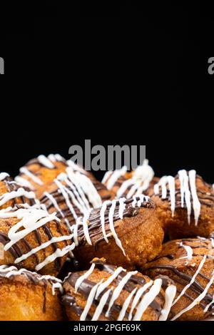 Kleine Cupcakes mit Kakao und weißer und Milchschokolade mit Sahne auf schwarzem Hintergrund Stockfoto