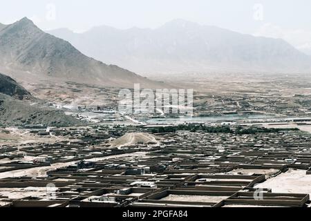 Ein Dorf unter dem Berg in Afghanistan. Ein typischer kleiner Dorfhaufen in der Nähe von Kabul. Stockfoto