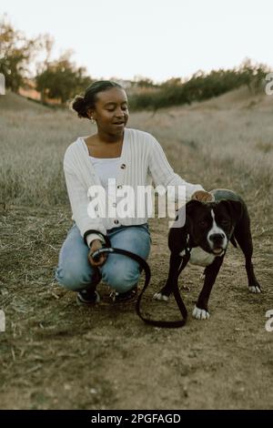 Ein Mädchen auf einem Feld mit ihrem Hund Stockfoto