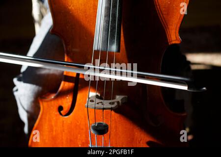 Nahaufnahme eines Cello, das im Sonnenlicht gespielt wird Stockfoto