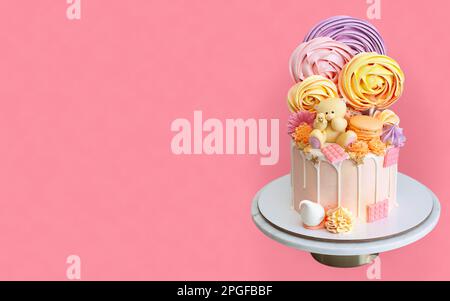 Zarter rosafarbener Kuchen zum Geburtstag des kleinen Mädchens niedlicher Teddybär, Schokolade und Baiser. Isoliert auf pinkfarbenem Hintergrund. Horizontale Ausrichtung Stockfoto