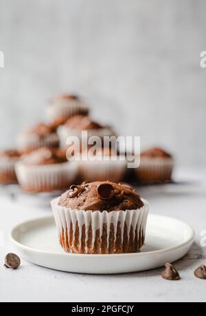 Nahaufnahme von Zucchini-Muffin mit Schokoladenchips auf weißem Hintergrund. Stockfoto
