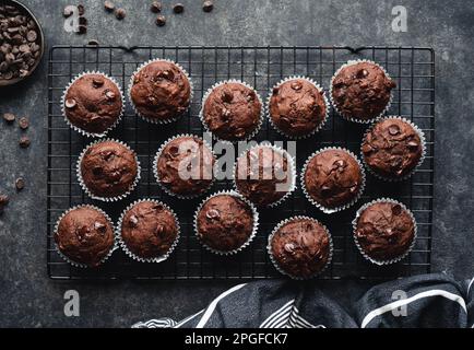 Über dem Regal mit Schokoladenzucchini-Muffins auf schwarzem Hintergrund. Stockfoto