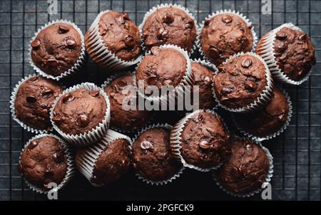 Nahaufnahme vieler Zucchini-Muffins mit Schokoladenchips auf schwarzem Hintergrund. Stockfoto