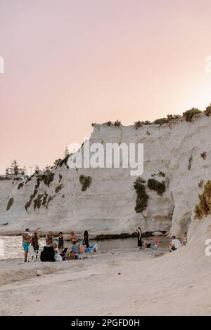 Schwimmen Sie im Sommer bei Sonnenuntergang an einem lokalen Strand in Malta Stockfoto