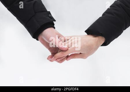 Mann und Frau, die im Winter Händchen halten Stockfoto