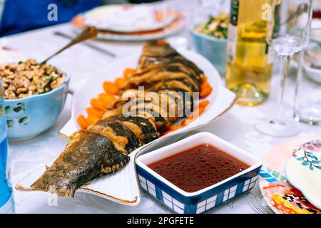 Pessachtisch mit traditionellem Pessachttteller. Gefilte Fish ist ein Gericht aus einer pochierten Mischung aus gemahlenem entbeintem Fisch. Es wird traditionell auf Sabbat und jüdischem Feiertagspasssover serviert. Stockfoto