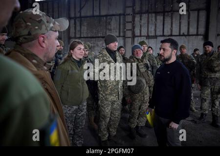 Bakhmut, Ukraine. 22. März 2023. Der ukrainische Präsident Wolodymyr Zelenskyy, richtig, unterhält sich mit Soldaten während eines Besuchs an den Frontpositionen in der Region Donezk am 22. März 2023 in Bakhmut, Ukraine. Zelenskyy hat die Moral erhöht und den Soldaten, die sich gegen die russische Invasion verteidigen, staatliche Medaillen verliehen. Kredit: Pool Photo/Pressestelle Des Ukrainischen Präsidenten/Alamy Live News Stockfoto