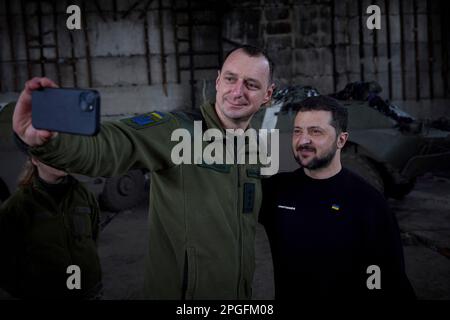 Bakhmut, Ukraine. 22. März 2023. Der ukrainische Präsident Wolodymyr Zelenskyy, rechts, posiert für ein Selfie mit einem Soldaten während eines Besuchs an den Frontpositionen in der Region Donezk am 22. März 2023 in Bakhmut, Ukraine. Zelenskyy hat die Moral erhöht und den Soldaten, die sich gegen die russische Invasion verteidigen, staatliche Medaillen verliehen. Kredit: Pool Photo/Pressestelle Des Ukrainischen Präsidenten/Alamy Live News Stockfoto