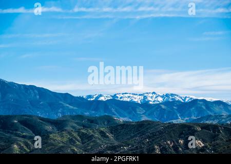 Die schneebedeckten Gipfel der Santa Ynez Berge im Winter, nachdem ein stimmungsvoller Fluss enorme Mengen an Feuchtigkeit in die Gegend brachte. Stockfoto