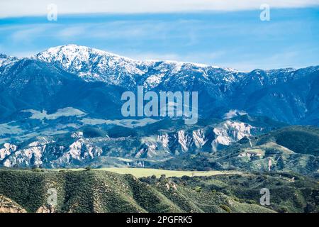 Die schneebedeckten Gipfel der Santa Ynez Berge im Winter, nachdem ein stimmungsvoller Fluss enorme Mengen an Feuchtigkeit in die Gegend brachte. Stockfoto