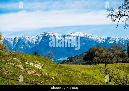 Die schneebedeckten Gipfel der Santa Ynez Berge im Winter, nachdem ein stimmungsvoller Fluss enorme Mengen an Feuchtigkeit in die Gegend brachte. Stockfoto